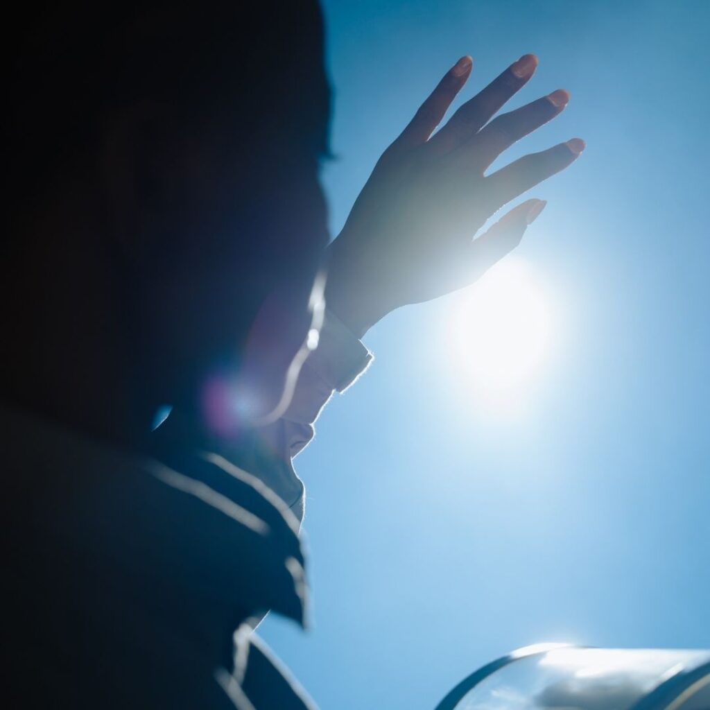 holding hand up to block sun glare